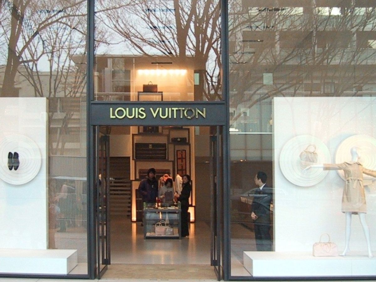 Several people at the entrance of the Louis Vuitton store on