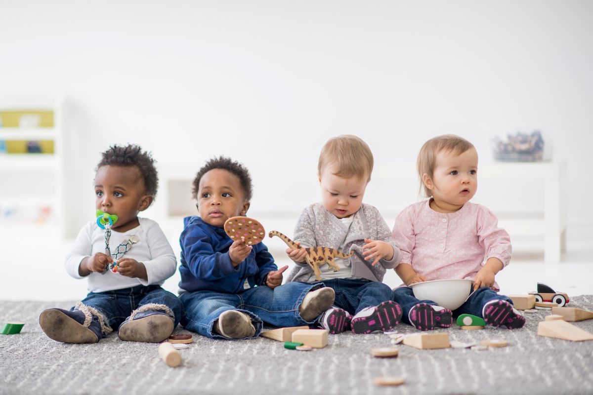 Babies playing with toys indoors at a daycare. (Getty Images)