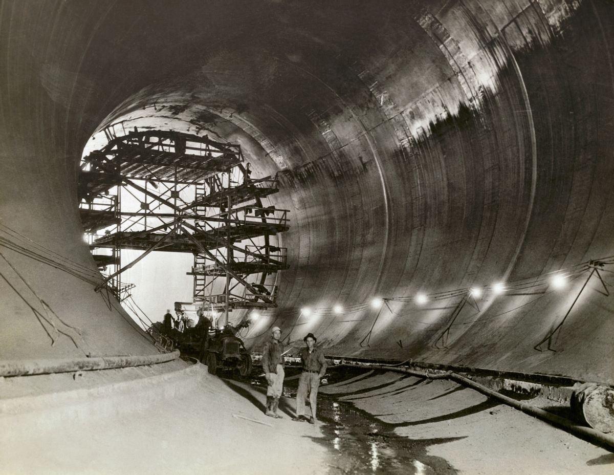 (Original Caption) View of Hoover Dam Tunnel. The concreting of the 50-foot tunnels, and the interstices surrounding rock adjacent to the three foot thick concrete lining is shown with a neat cement gout under high pressure. [?] This recent photo shows the grouting process in operation in Diversion Tunnel No. 4, through which the Colorado River will be diverted during the latter part of November. (Photo by George Rinhart/Corbis via Getty Images) (George Rinhart/Corbis via Getty Images)
