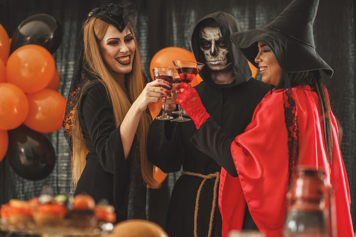Friends are having costume party for Halloween. They are wearing vampire's, grim reaper's and witch's costume and celebrating. (Getty Images)