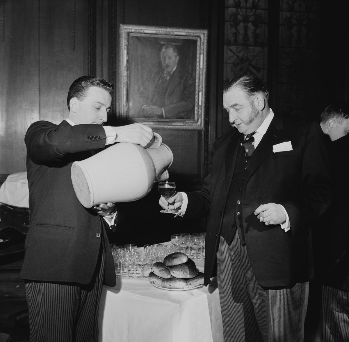 Liveryman Arthur Peters of the Stationers' Company receives ale from a jug held by beadle and butler, Douglas Rowland, at the Stationers' Hall in the City of London, during the annual Cakes And Ale Ceremony, 27th February 1963. The ceremony dates back to 1612, when Alderman John Norton left a bequest to provide Liverymen with a 'feast of cakes and ale' every Ash Wednesday. (Photo by Keystone/Hulton Archive/Getty Images) (Keystone/Hulton Archive/Getty Images)