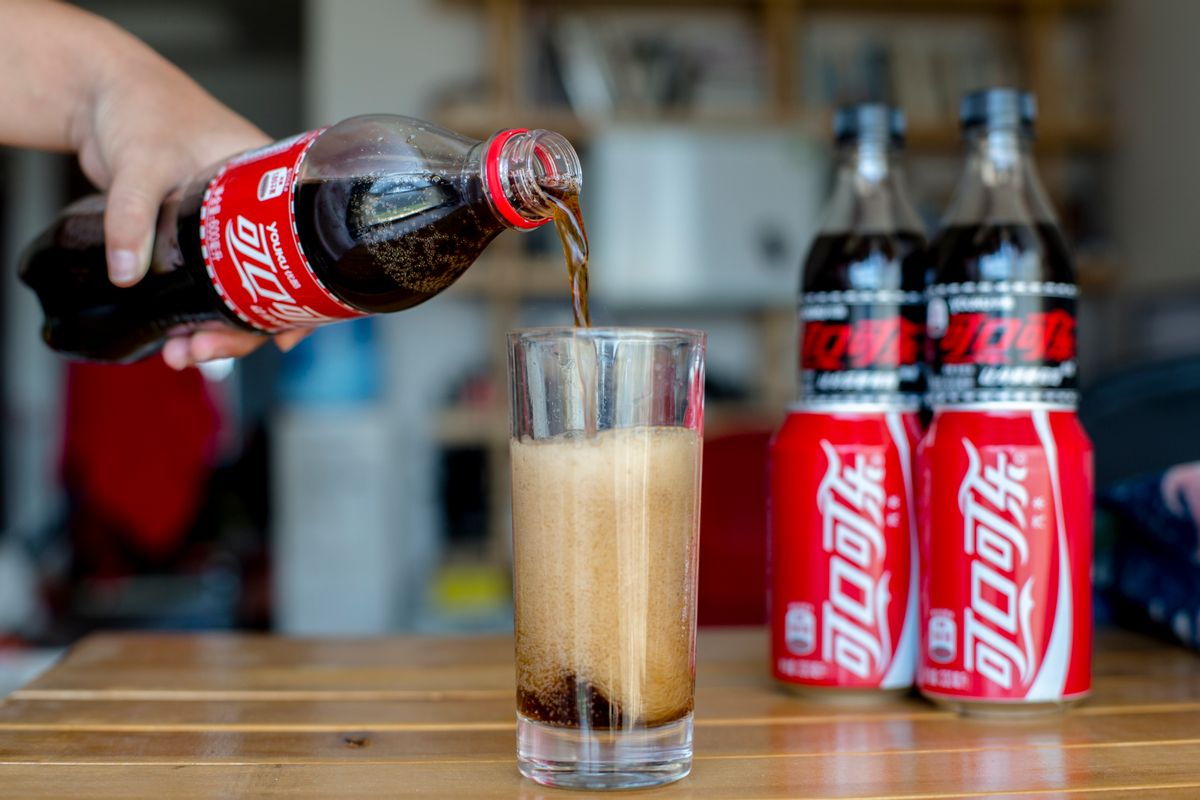 BEIJING, CHINA - 2015/08/15: Pouring Coca Cola into a glass on a dining table. The strong dollar hit Coca-Colas overseas operations, particularly in China. (Photo by Zhang Peng/LightRocket via Getty Images) (Zhang Peng/LightRocket via Getty Images)