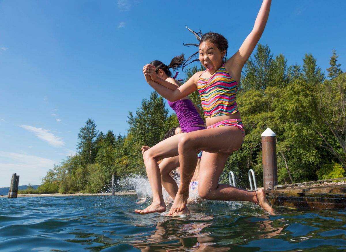 Girls jumping together into lake (Getty Images)