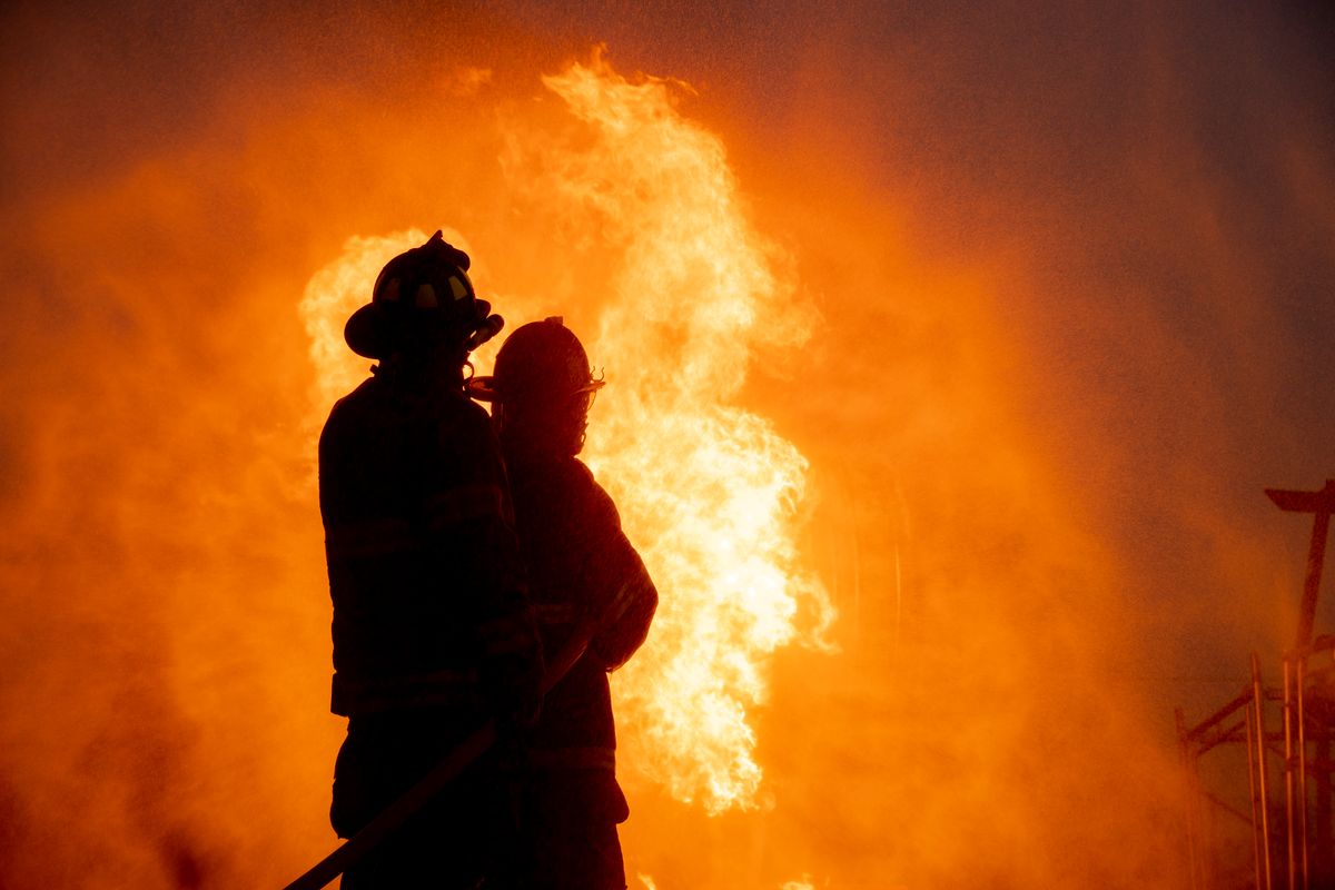 Silhouette of two firefighter in front of the big fire, Fire insurance concept. (Getty Images/Virojt Changyencham) (Getty Images/Virojt Changyencham)