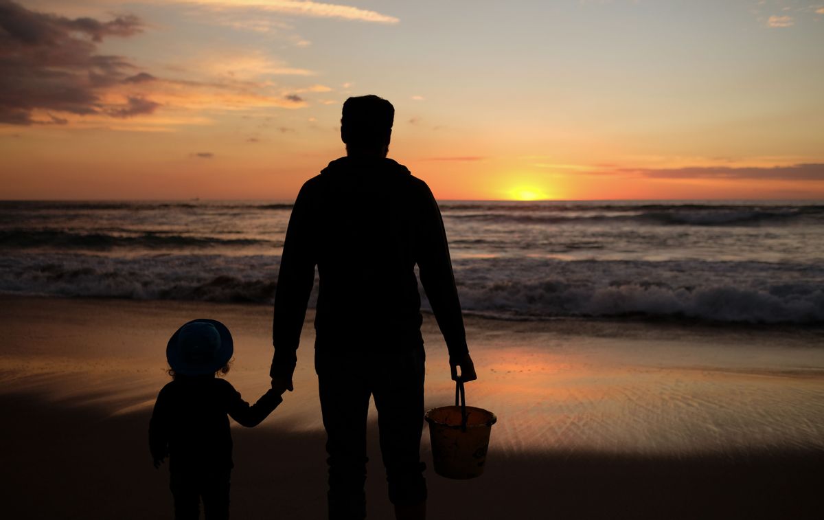 A dad and his daughter enjoy the last sunset of the year in Manhattan Beach, California, on December 31, 2018. (Photo by Chris Delmas / AFP)        (Photo credit should read CHRIS DELMAS/AFP/Getty Images) (CHRIS DELMAS/AFP/Getty Images)
