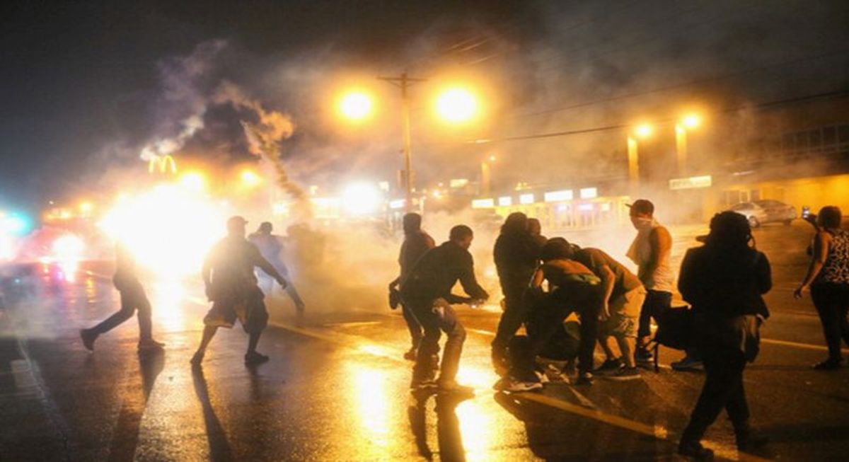 FERGUSON, MO - AUGUST 17:  Police fire tear gas at demonstrators protesting the shooting of Michael Brown after they refused to honor the midnight curfew on August 17, 2014 in Ferguson, Missouri. The curfew was imposed on Saturday in an attempt to reign in the violence that has erupted nearly every night in the suburban St. Louis town since the shooting death of teenager Michael Brown by a Ferguson police officer on August 9.  (Photo by Scott Olson/Getty Images)