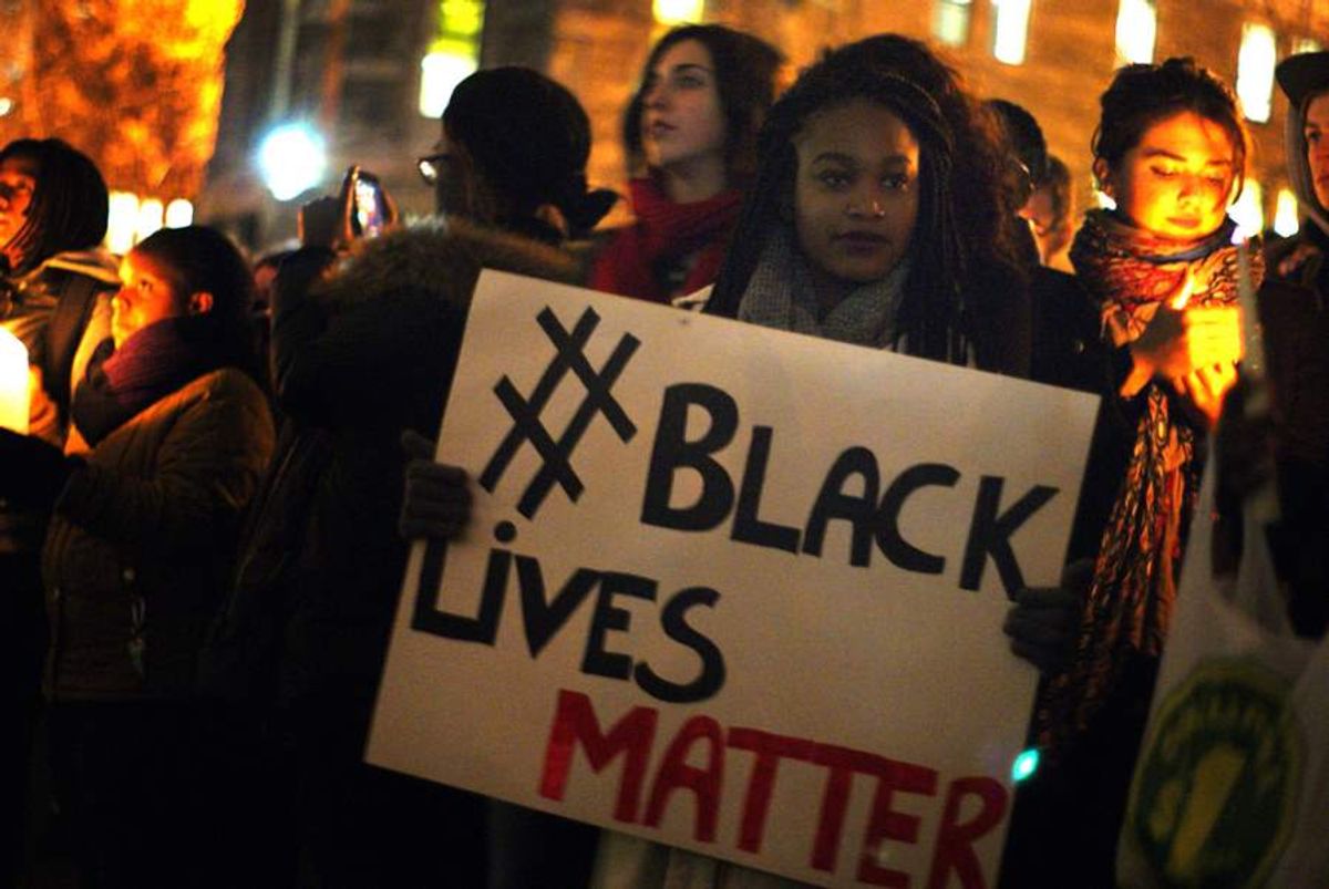 A woman holds up a #BlackLivesMatter sign during a vigil at McGill University in Montreal on 25 November 2014. (Gerry Lauzon)