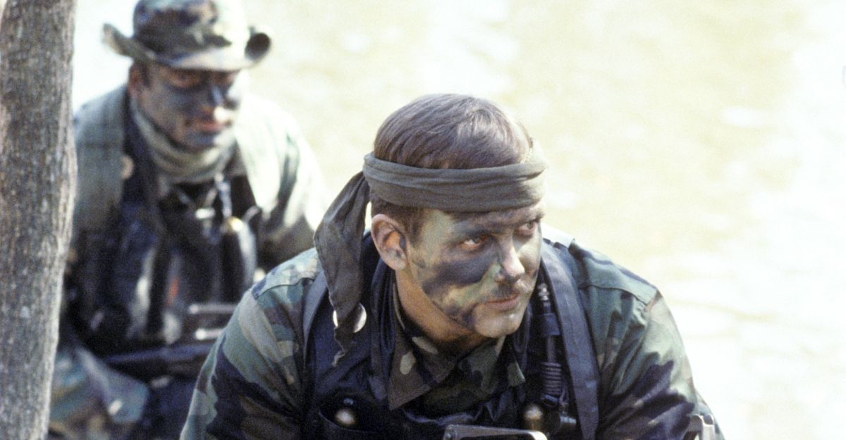 Boatswain's Mate 1st Class Mark Blasen, foreground, and Photographer's Mate 2nd Class Peter Rogers, both members of Sea-Air-Land (SEAL) Team 4, participate in a training exercise.  Blasen is armed with a 5.56 mm Colt Commando assault rifle/submarine gun.  All Hands - April 1985. (U.S. Navy / Wikimedia Commons)