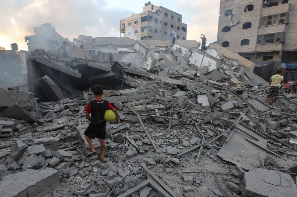 TOPSHOT - A picture taken on August 9, 2018 shows a boy looking at the rubble of the Said al-Mishal Cultural Centre following an Israeli air strike on Gaza City. - At least 18 Palestinians were wounded as Israel struck a building in central Gaza City, the health ministry in the Palestinian enclave said, after hours of relative calm. The strike hit a building that Palestinians say housed a cultural centre and other offices in the middle of the city, an AFP correspondent said. Israel's military had not commented. (Photo by MAHMUD HAMS / AFP)        (Photo credit should read MAHMUD HAMS/AFP/Getty Images) (Getty Images)