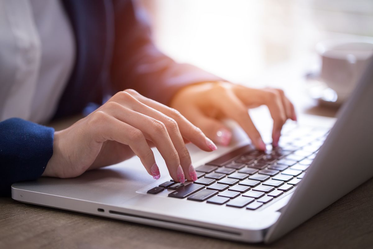 Close-up of hands typing on laptop keyboard in the office. (Getty Images)