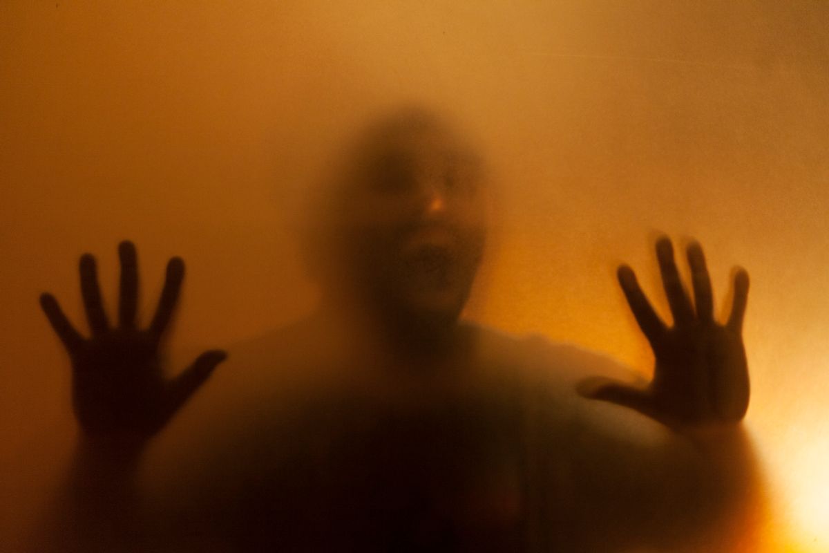 Man screaming with anger behind translucent surface (Getty Images)