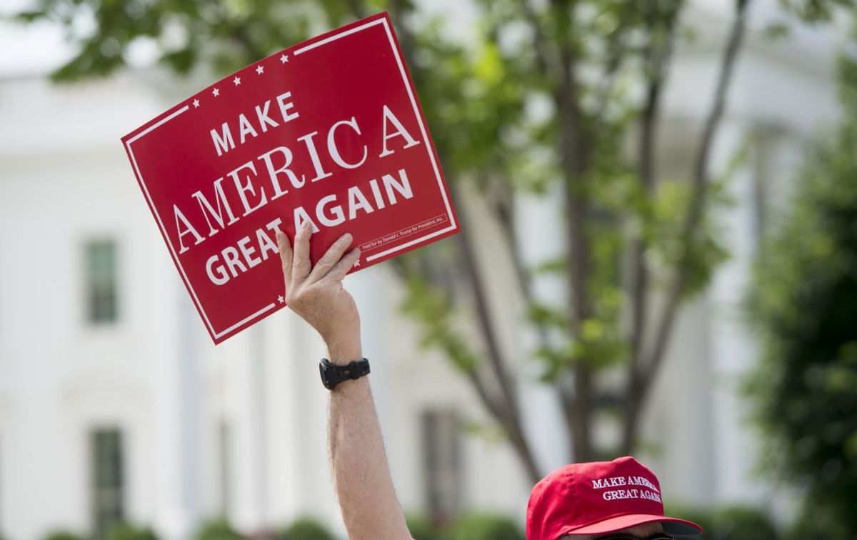A man holds a Make America Great Again sign as supporters of US President Donald Trump and his policies demonstrate during a "Pittsburgh Not Paris" rally in support of his decision to withdraw the US from the Paris Climate Accord during a rally in Lafayette Square next to the White House in Washington, DC, on June 3, 2017. / AFP PHOTO / SAUL LOEB        (Photo credit should read SAUL LOEB/AFP/Getty Images) (Getty Images)