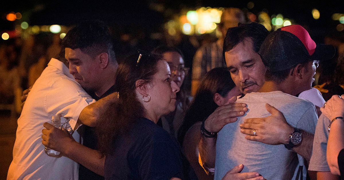 Family of Walmart shooting victims embrace during a candlelight vigil at the Immanuel Church for victims of a shooting that left a total of 22 people dead at the Cielo Vista Mall WalMart in El Paso, Texas, on August 5, 2019. - A shooting at a Walmart store in Texas left multiple people dead. At least one suspect was taken into custody after the shooting in the border city of El Paso, triggering fear and panic among weekend shoppers as well as widespread condemnation. It was the second fatal shooting in less than a week at a Walmart store in the US and comes after a mass shooting in California last weekend. (Photo by Mark RALSTON / AFP) (MARK RALSTON/AFP/Getty Images)