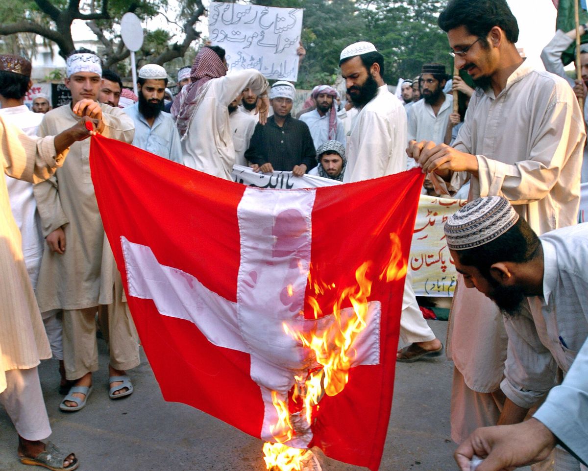 Karachi, PAKISTAN:  Pakistani Muslims torch a Danish flag during a demonstration in Karachi, 23 February 2006. Pakistani hardline Islamic parties continued country wide protests denouncing the publication of cartoons depicting Prophet Mohammed in several European newspapers. Five people died last week during anti-cartoon protests in Lahore and Peshawar that targeted Western businesses. AFP PHOTO/Rizwan TABASSUM  (Photo credit should read RIZWAN TABASSUM/AFP/Getty Images) (Getty Images)