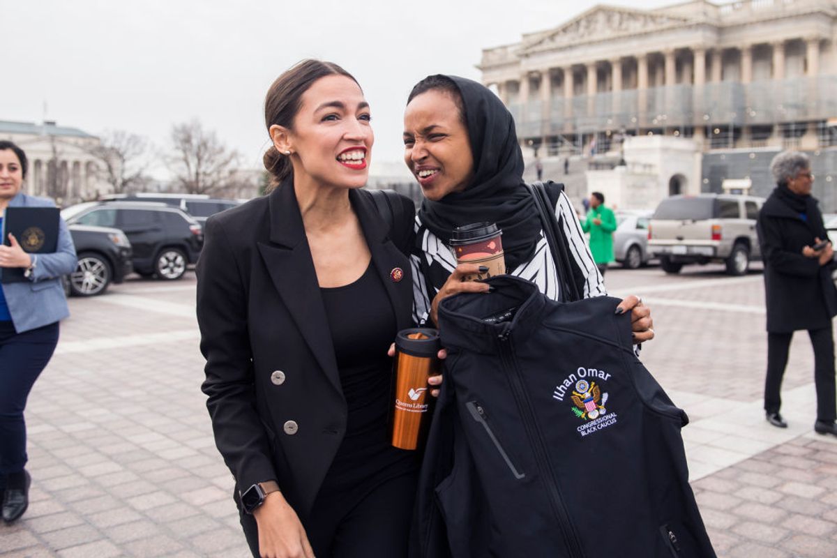 UNITED STATES - JANUARY 04: Reps. Alexandria Ocasio-Cortez, D-N.Y., left, and Ilhan Omar, D-Minn., arrive for a group photos with Democratic women members of the House on the East Front of the Capitol on January 4, 2019. Omar is holding a Congressional Black Caucus jacket bearing her name. (Photo By Tom Williams/CQ Roll Call)
