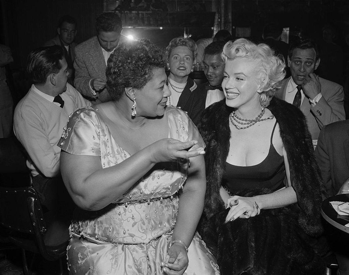 (Original Caption) 11/19/1954- Hollywood, CA: Marilyn meets Ella. Looking fit and well-groomed after her recent hospitalization, actress Marilyn Monroe (right) attends a jazz session at the Tiffany Club in Hollywood. Singer Ella Fitzgerald chats with Marilyn, who was escorted by columnist Sydney Skolsky. (Getty Images/Stock photo)
