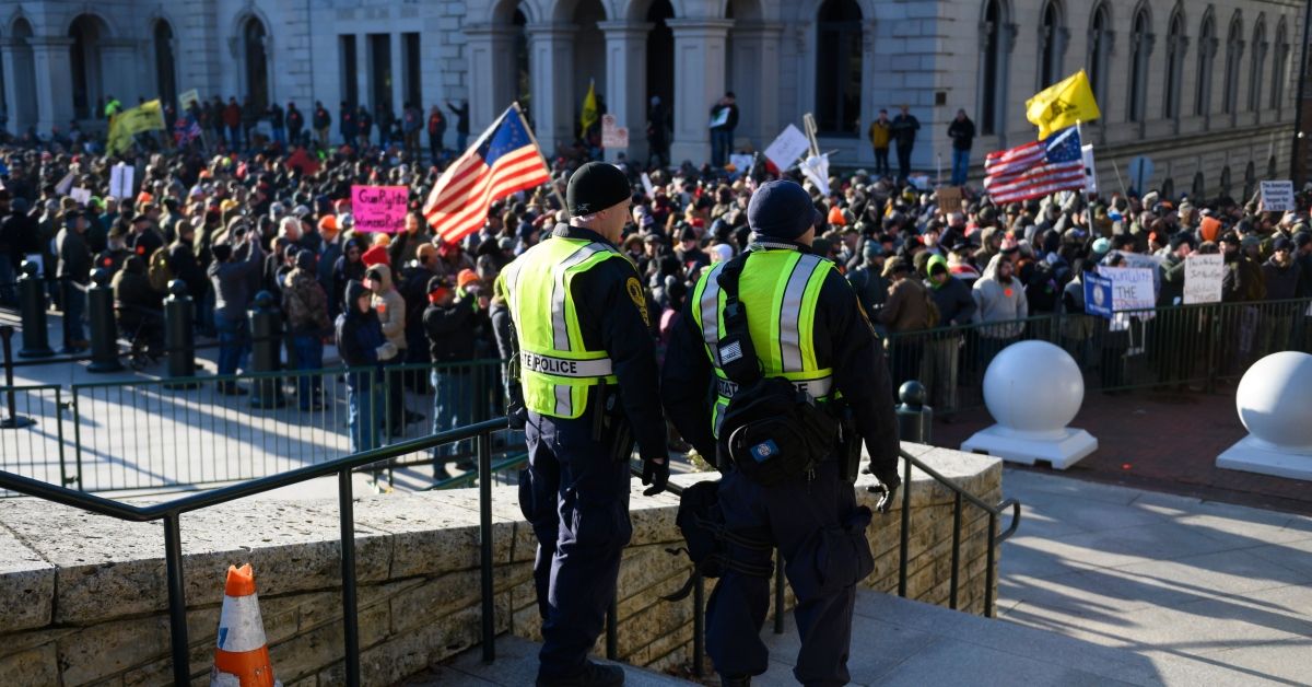 Virginia State police keep watch over a crowd gathered in front of the Virginia State Capitol in Richmond, Virginia on January 20, 2020. - Several thousand gun rights supporters massed near the Virginia state capitol Monday for a rally under heavy surveillance and a state of emergency declared by authorities fearing violence by far-right groups. Dressed in hunting jackets and caps, rally-goers were checked for weapons as they passed through tight security before entering a fenced off area of Richmond's Capitol Square for the so-called "Lobby Day" event. (Photo by Roberto SCHMIDT / AFP) (Photo by ROBERTO SCHMIDT/AFP via Getty Images) ( ROBERTO SCHMIDT/AFP via Getty Images)