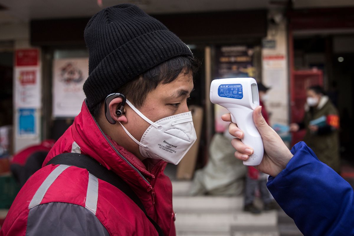 WUHAN, CHINA - JANUARY 29: (CHINA OUT)  A community worker checks the temperature of courier in an Express station on January 29, 2020 in Hubei Province, Wuhan, China. Due to a transit shut down and lack of supplies, couriers have became the city's suppliers. The 2019 coronavirus (2019-nCoV), which originated in Wuhan, China, has infected 6078 people and killed at least 132, mostly in China. (Photo by Getty Images) (Getty Images)