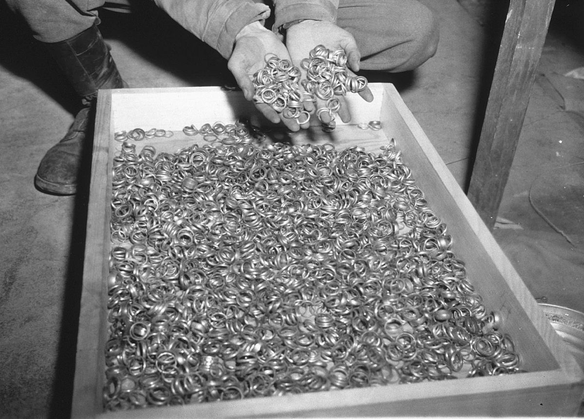 A US soldier inspects thousands of gold wedding bands taken from jews by the Nazi's and stashed in the Heilbronn Salt Mines May 3, 1945 in Germany. The treasures were uncovered by allied forces after the defeat of Nazi Germany. (Getty Images)