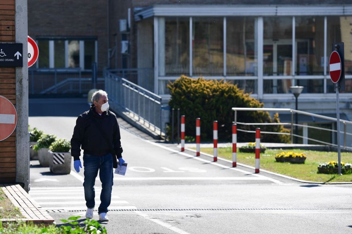A man wearing a protective mask leaves the hospital in Codogno, southeast of Milan, on March 11, 2020 a day after Italy imposed unprecedented national restrictions on its 60 million people Tuesday to control the deadly COVID-19 coronavirus. (Photo by Miguel MEDINA / AFP) (Photo by MIGUEL MEDINA/AFP via Getty Images) (Getty Images)