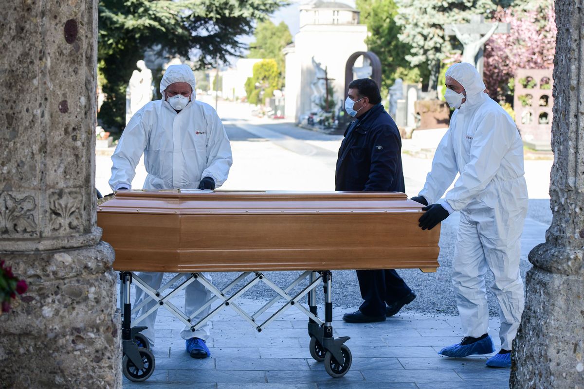 Undertakers wearing a face mask and overalls unload a coffin out of a hearse on March 16, 2020 at the Monumental cemetery of Bergamo, Lombardy, as burials of people who died of the new coronavirus are being conducted at the rythm of one every half hour. (Photo by Piero Cruciatti / AFP) (Photo by PIERO CRUCIATTI/AFP via Getty Images) (PIERO CRUCIATTI/AFP via Getty Images)