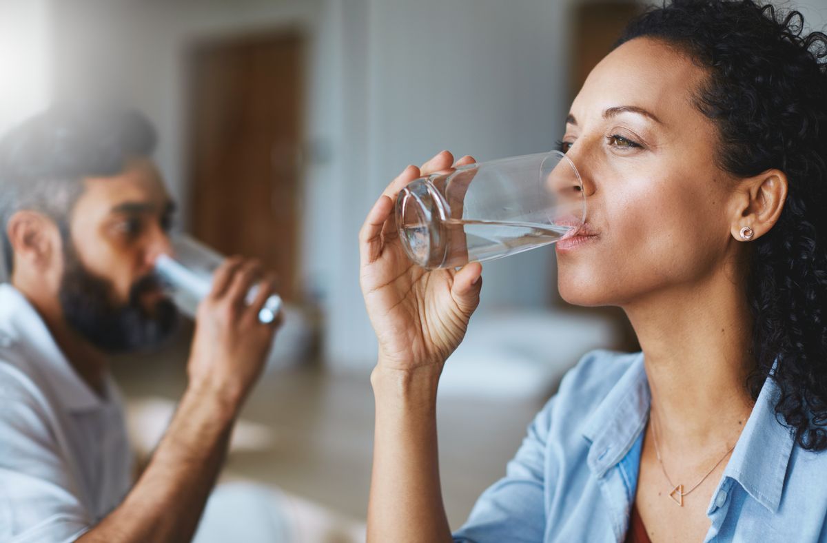 Shot of a couple drinking glasses of water together at home (Getty Images, stock)