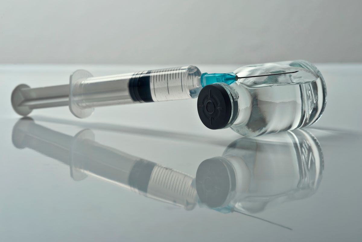 Injectable medications in sealed vials and a disposable plastic medical syringe against gray background.Studio shot (Getty Images/Stock photo)