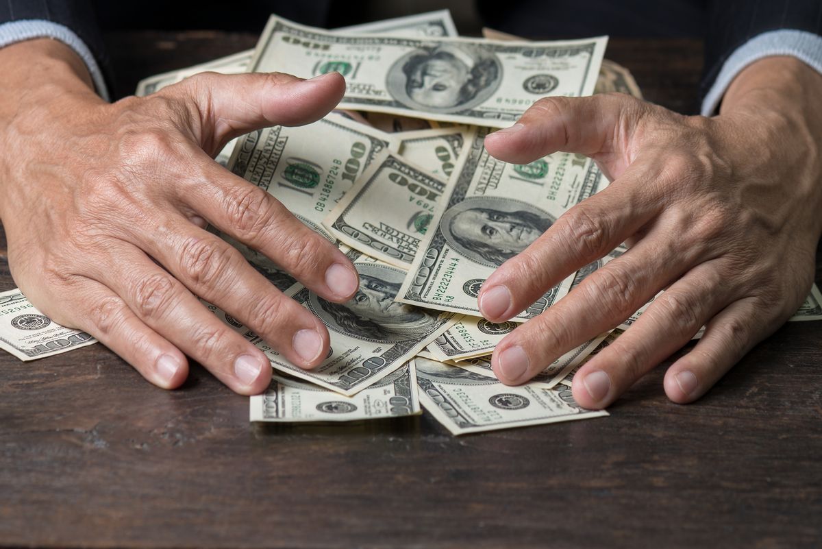 Man hands sweeping money,business concept.
Lucky man winning  lots of us dollar from gambling,with smiling face and black background. (Man hands sweeping money,business concept.
Lucky man winning  lots of us dollar from gambling,with smiling face and (Getty Images)