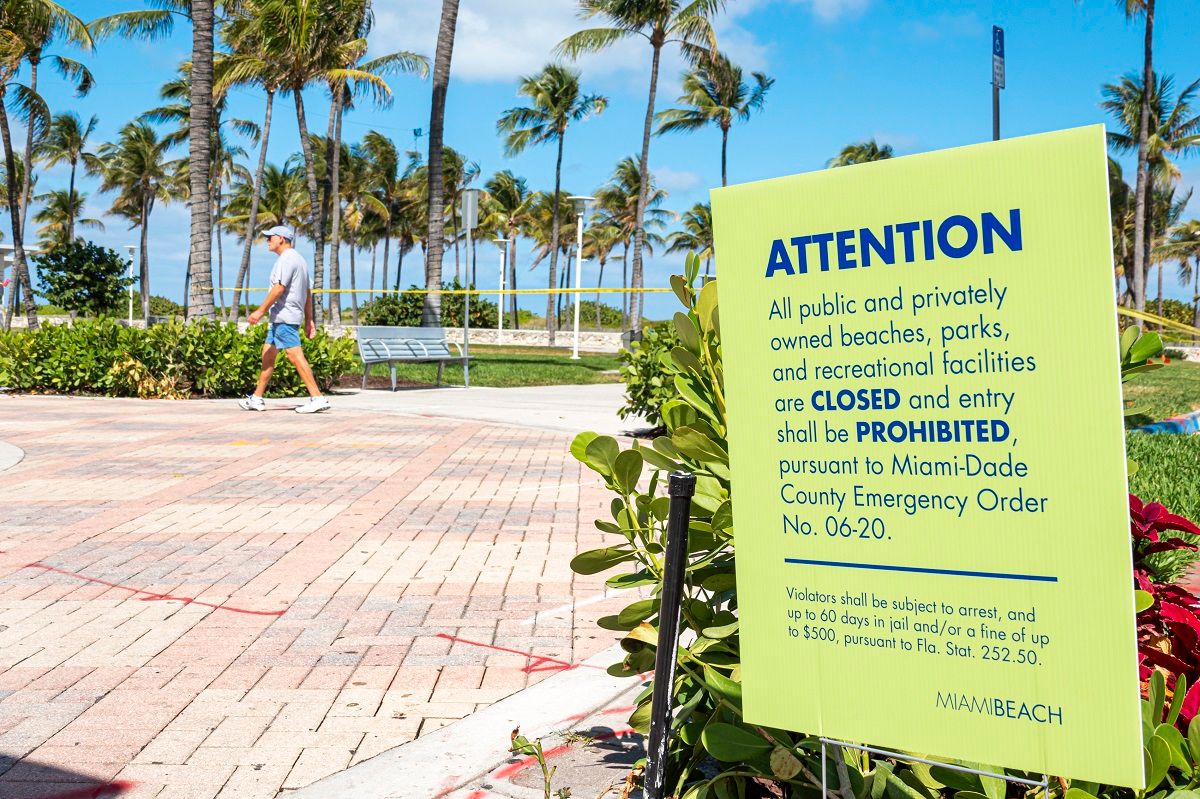 Miami Beach, Lummus Park, closed due to Pandemic sign and man walking . (Photo by: Jeffrey Greenberg/Education Images/Universal Images Group via Getty Images) (Jeff Greenberg / Universal Images Group via Getty Images)