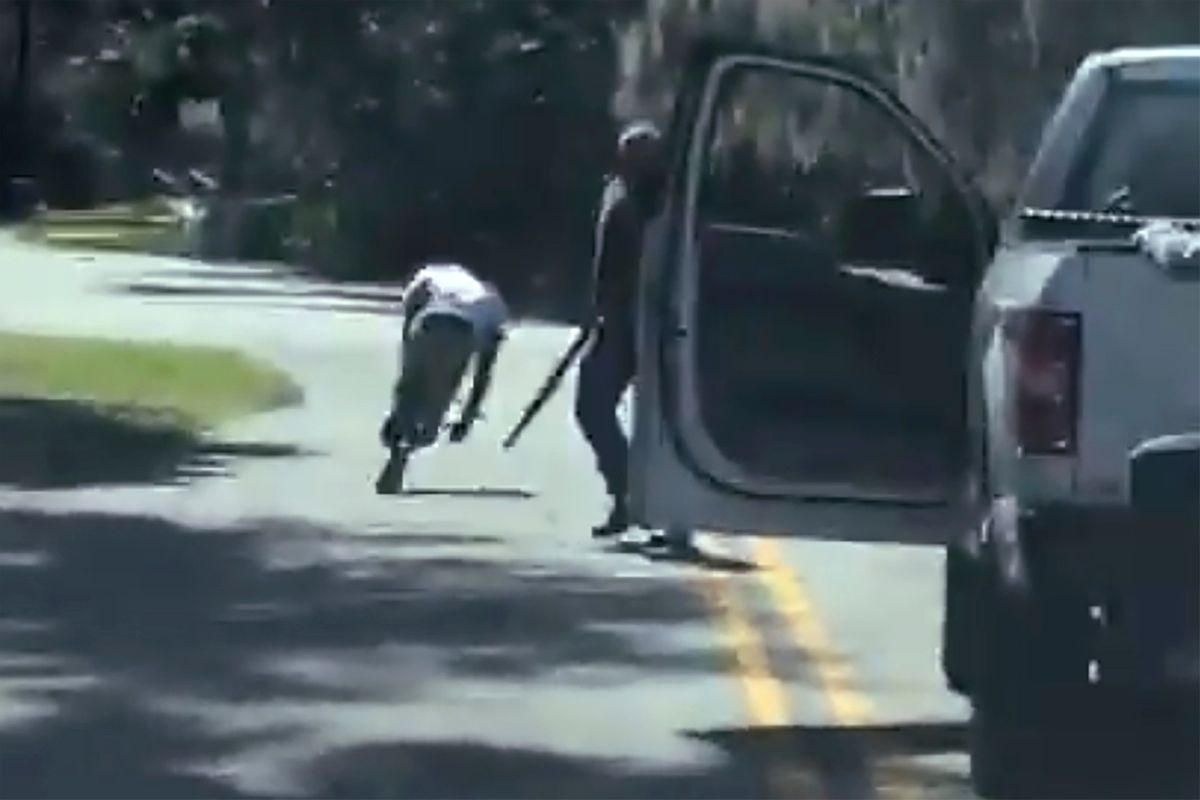 ADDS THAT THE AP HAS NOT BEEN ABLE TO VERIFY THE SOURCE OF THE VIDEO - This image from video posted on Twitter Tuesday, May 5, 2020, purports to show Ahmaud Arbery stumbling and falling to the ground after being shot as Travis McMichael stands by holding a shotgun in a neighborhood outside Brunswick, Ga., on Feb. 23, 2020. The AP has not been able to verify the source of the video. (Twitter via AP) (Twitter via AP)