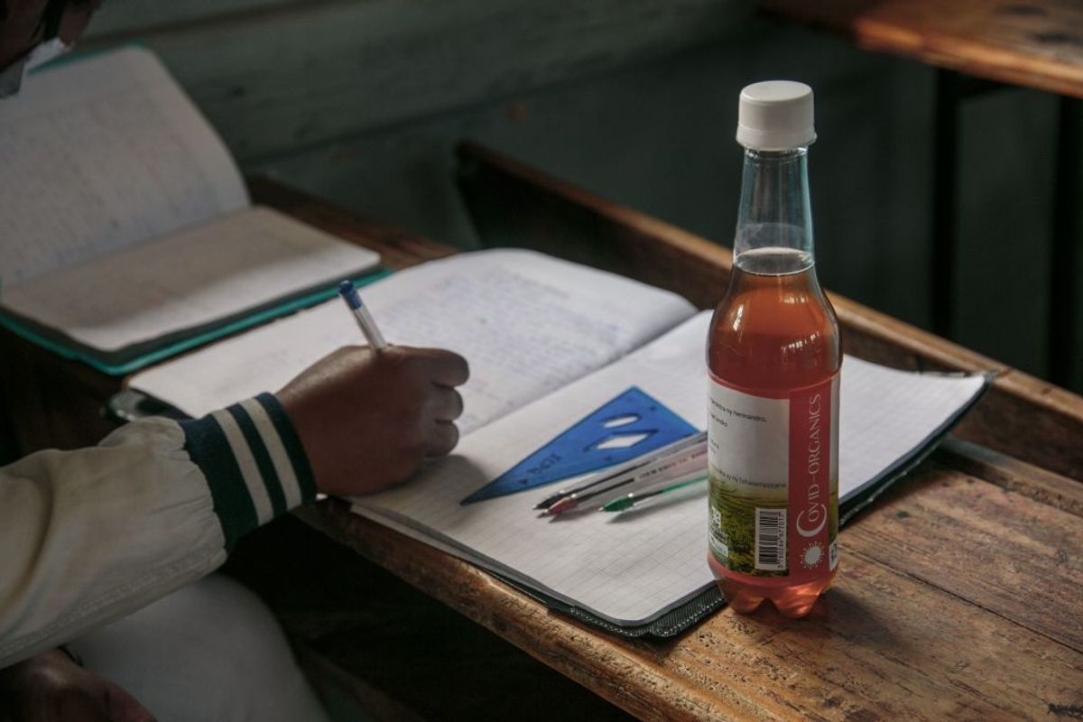 A bottle of Covid Organics, a herbal tea, touted by Madagascar President Andry Rajoelina as a powerful remedy against the COVID-19 coronavirus, that the authorities gave each student and encouraged them to drink it before the start of classes is seen on a student's desk at the J.J. Rabearivelo High School in downtown Antananarivo on April 23 2020. (Photo by RIJASOLO / AFP) (Photo by RIJASOLO/AFP via Getty Images) (Getty Images)