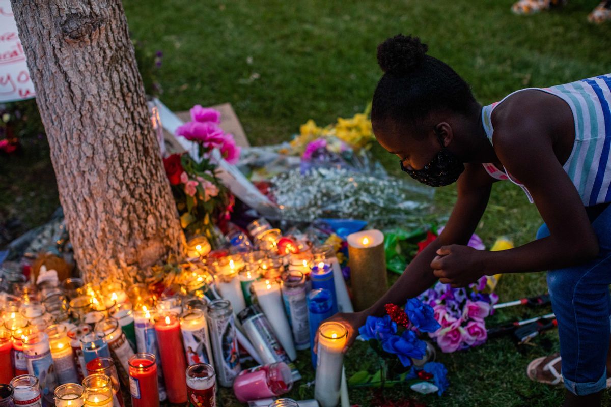 Honesty Strickland lights up a candel during a vigil, around a makeshift memorial at the tree where Robert Fuller was found dead outside Palmdale City Hall on June 13, 2020, to demand a full investigation into the death of Robert Fuller, a 24-year-old black man found hanging from a tree, in Palmdale, California. - Protesters blasted city and sheriff's officials for quickly deeming it a suicide without exploring the possibility of a hate crime. Robert Fuller's body was found with a rope around his neck, hanging from a tree just before 4 am on June 10, 2020, in Poncitlan Square, across from City Hall, according to Lt. Brandon Dean of the Los Angeles County Sheriff's Department. (Photo by Apu GOMES / AFP) (Photo by APU GOMES/AFP via Getty Images) (APU GOMES/AFP via Getty Images)