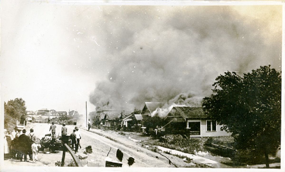 A group of people looking at smoke in the distance coming from damaged properties following the Tulsa Race Massacre, Tulsa, Oklahoma, June 1921. (Photo by Oklahoma Historical Society/Getty Images) (Oklahoma Historical Society / Getty Images)