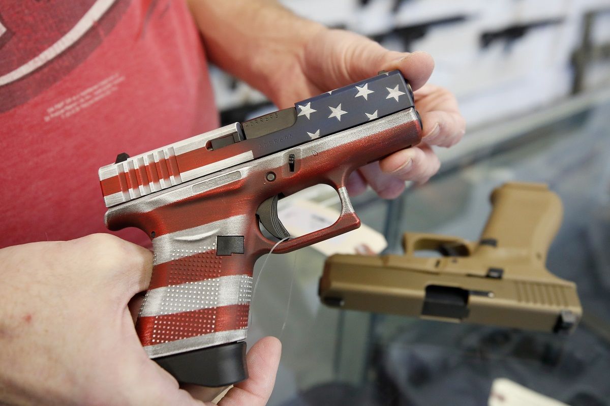 A worker restocks handguns at Davidson Defense in Orem, Utah on March 20, 2020. - Gun stores in the US are reporting a surge in sales of firearms as coronavirus fears trigger personal safety concerns. (Photo by GEORGE FREY / AFP) (Photo by GEORGE FREY/AFP via Getty Images) (George Frey / AFP via Getty Images)