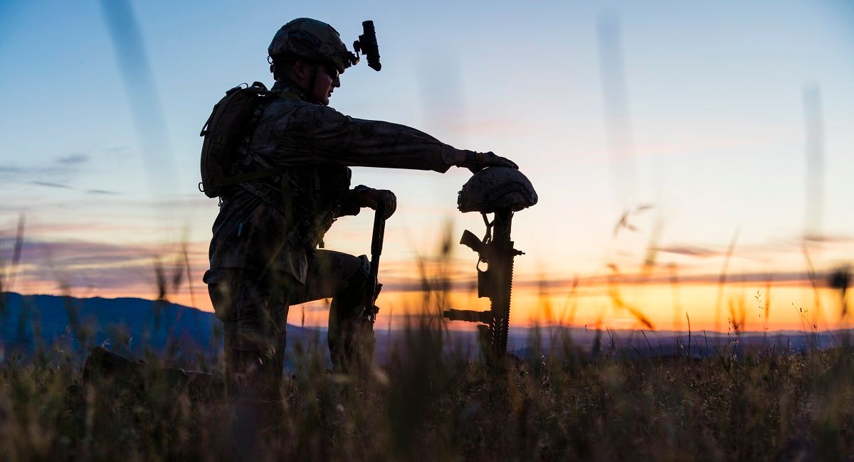 Sad Soldier Kneeling for Honoring His Fallen Friend (Getty Images /  guvendemir)