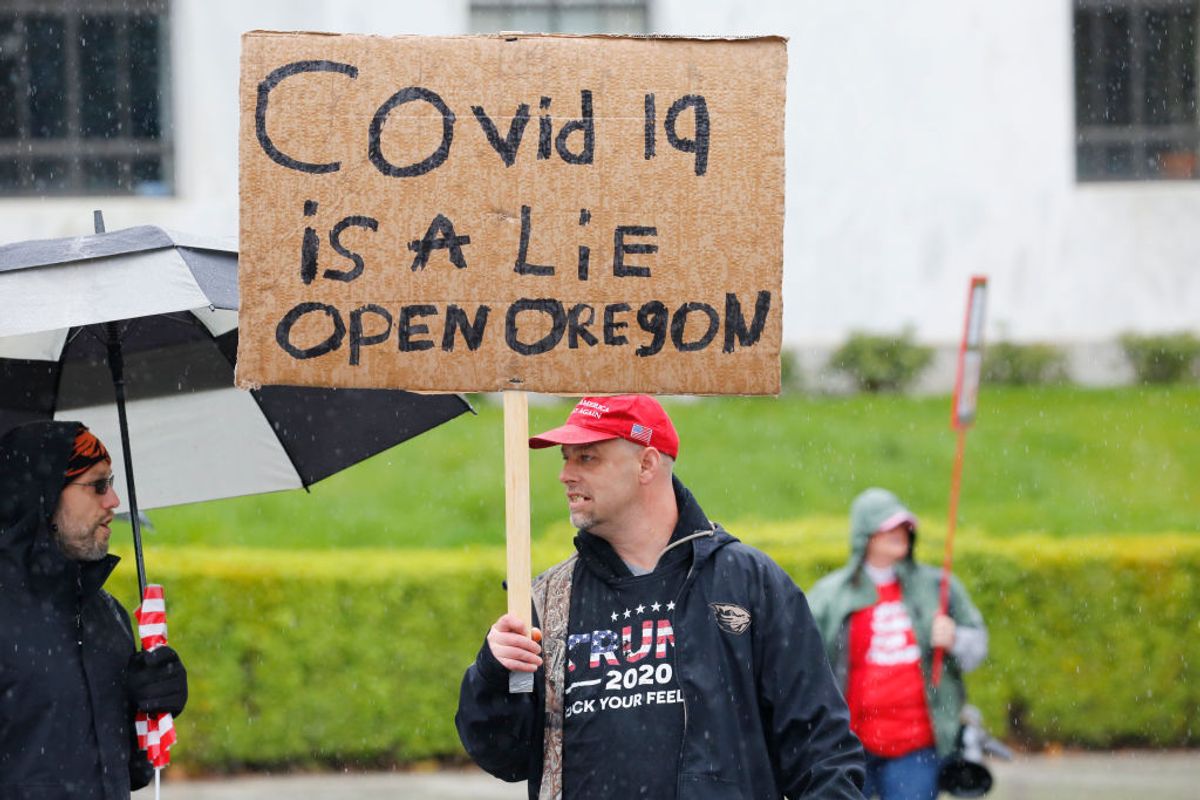 SALEM, OR - MAY 02: Gary Davis, of Albany, holds a sign saying Covid 19 is a lie, open Oregon at the ReOpen Oregon Rally on May 2, 2020 in Salem, Oregon. Demonstrators gathered at the state capitol to demand a reopening of the state and to protest Gov. Kate Brown's stay-at-home order which was put in place to slow the spread of the coronavirus (COVID-19). (Photo by Terray Sylvester/Getty Images) (Photo by Terray Sylvester/Getty Images)