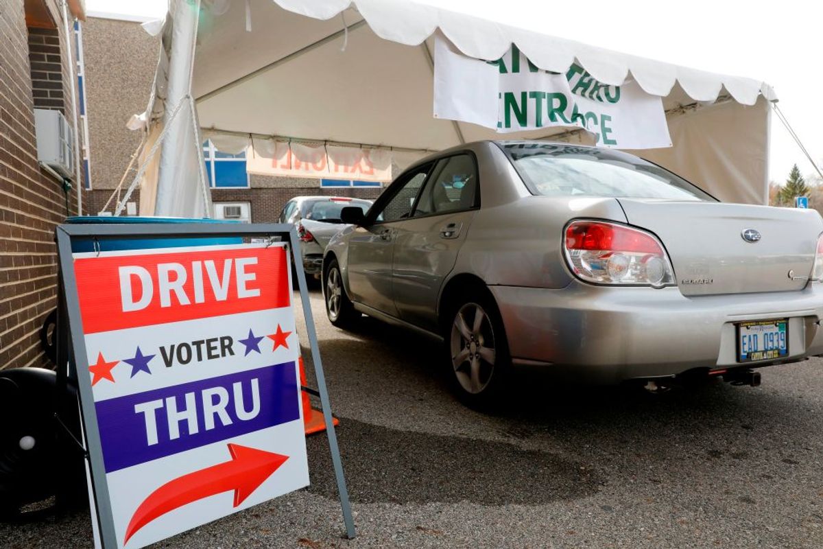 People drive up to get their absentee ballots at the city of Lansing Clerk's Election Unit on November 2, 2020 in Lansing, Michigan. - In Michigan workers can not scan absentee ballots until 7am ET on election day. (Photo by JEFF KOWALSKY / AFP) (Photo by JEFF KOWALSKY/AFP via Getty Images) (Getty Images)