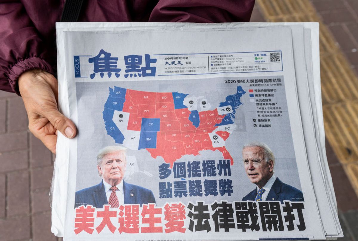 HONG KONG, CHINA - 2020/11/14: A woman distributes Chinese language newspapers featuring on its front cover the US presidential race between current president Donald J. Trump and president-elect Joe Biden in Hong Kong. (Photo by Miguel Candela/SOPA Images/LightRocket via Getty Images) (Getty Images)
