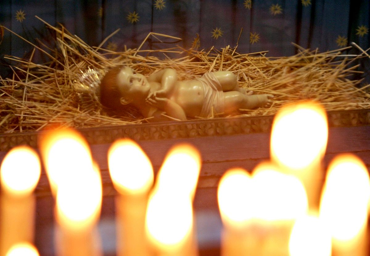 BETHLEHEM, WEST BANK - DECEMBER 18: A doll representing the infant Jesus is seen behind votive candles as it lies on a bed of straw in St. Catherine's, the Franciscan church alongside the Church of the Nativity, the traditional birthplace of Jesus, during Sunday mass December 18, 2005 in the West Bank town of Bethlehem. Less than a week before Christmas, the biblical town on the outskirts of Jerusalem remains surrounded by the Israeli separation barrier and army checkpoints which residents say dampen the festive spirit and drive pilgrims away. (Photo by David Silverman/Getty Images) (David Silverman / Getty Images)