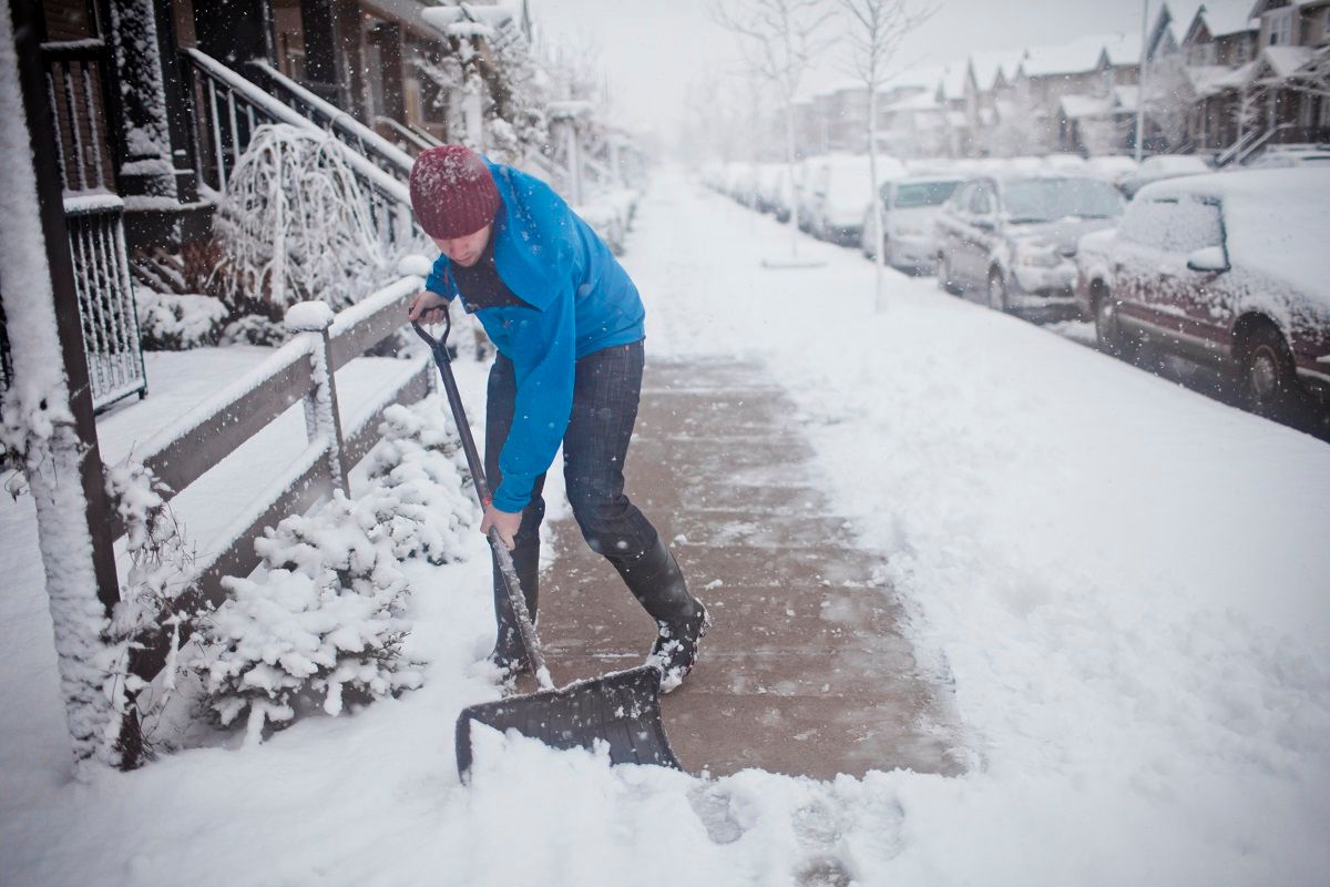 A man shovels the sidewalk outside of his suburban house during a snow storm. (Christopher Kimmel via Getty Images)