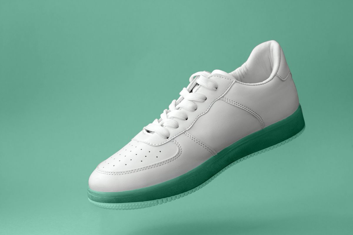 beautiful white sports sneakers with mint colored soles levitate on a mint background (Getty Images, stock)