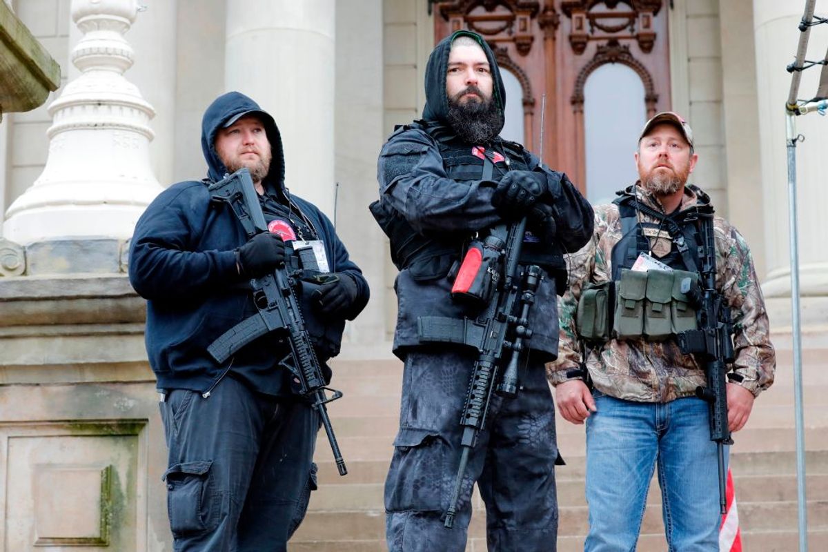 Michael Null (L) takes part in the American Patriot Rally, organized by Michigan United for Liberty, to demand the reopening of businesses on the steps of the Michigan State Capitol in Lansing, Michigan, on April 30, 2020. Other men are unidentified. - Thirteen men, including members of two right-wing militias, have been arrested for plotting to kidnap Michigan Governor Gretchen Whitmer and "instigate a civil war", Michigan Attorney General Dana Nessel announced on October 8, 2020. The Nulls were charged for their alleged roles in the plot to kidnap Whitmer, according to the FBI. The brothers are charged with providing support for terroristic acts and felony weapons charges. (Photo by JEFF KOWALSKY / AFP) (Photo by JEFF KOWALSKY/AFP via Getty Images) (JEFF KOWALSKY/AFP via Getty Images)