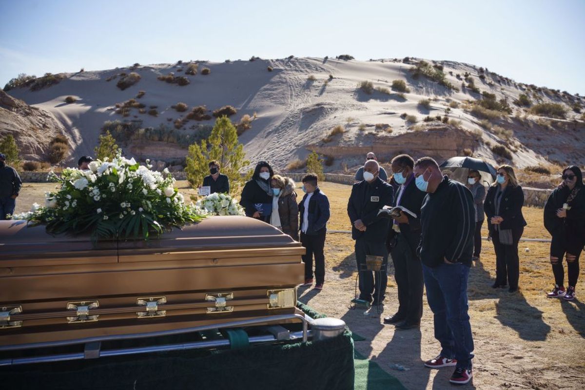 TOPSHOT - Family and friends attend the funeral of Humberto Rosales, who passed away from Covid-19 complications, at Memorial Pines Cemetery in Santa Teresa, New Mexico, on December 3, 2020. - Humberto Rosales, who was 49, worked as a care provider at a psychiatric hospital and passed away from Covid-19 complications on November 19. (Photo by Paul Ratje / AFP) (Photo by PAUL RATJE/AFP via Getty Images) (Getty Images)