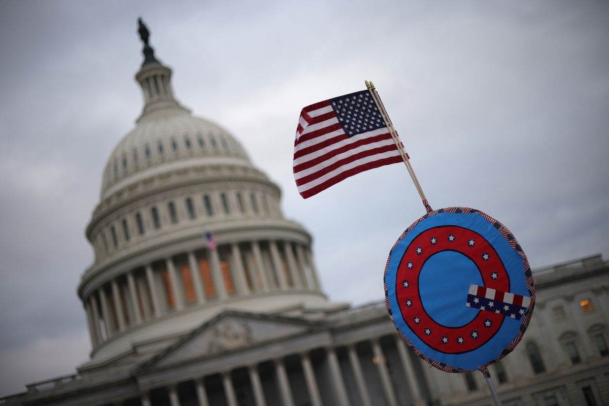 WASHINGTON, DC - JANUARY 06: Supporters of U.S. President Donald Trump fly a U.S. flag with a symbol from the group QAnon as they gather outside the U.S. Capitol January 06, 2021 in Washington, DC. Congress will hold a joint session today to ratify President-elect Joe Biden's 306-232 Electoral College win over President Donald Trump. A group of Republican senators have said they will reject the Electoral College votes of several states unless Congress appointed a commission to audit the election results. (Photo by Win McNamee/Getty Images)