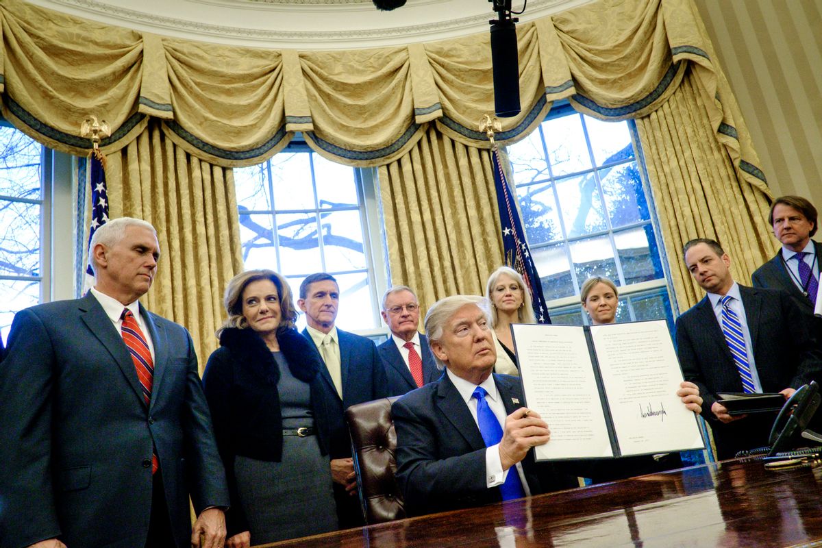WASHINGTON, DC - JANUARY 28: President Donald Trump holds up one of the executive actions that he signed in the Oval Office on January 28, 2017 in Washington, DC. The actions outline a reorganization of the National Security Council, implement a five year lobbying ban on administration officials and a lifetime ban on administration officials lobbying for a foreign country and calls on military leaders to present a report to the president in 30 days that outlines a strategy for defeating ISIS.  (Photo by Pete Marovich - Pool/Getty Images) (Pete Marovich - Pool/Getty Images)
