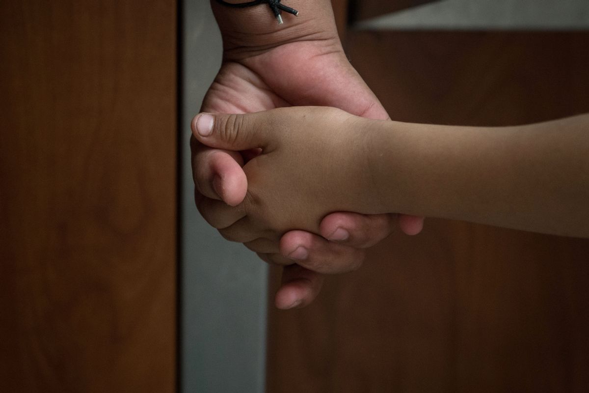 A Honduran asylum seeker, recently released from federal detention with fellow migrants, holds the hand of her six-year-old daughter at a bus depot on June 11, 2019, in McAllen, Texas. (Photo by Loren ELLIOTT / AFP)        (Photo credit should read LOREN ELLIOTT/AFP via Getty Images) (LOREN ELLIOTT/AFP via Getty Images)