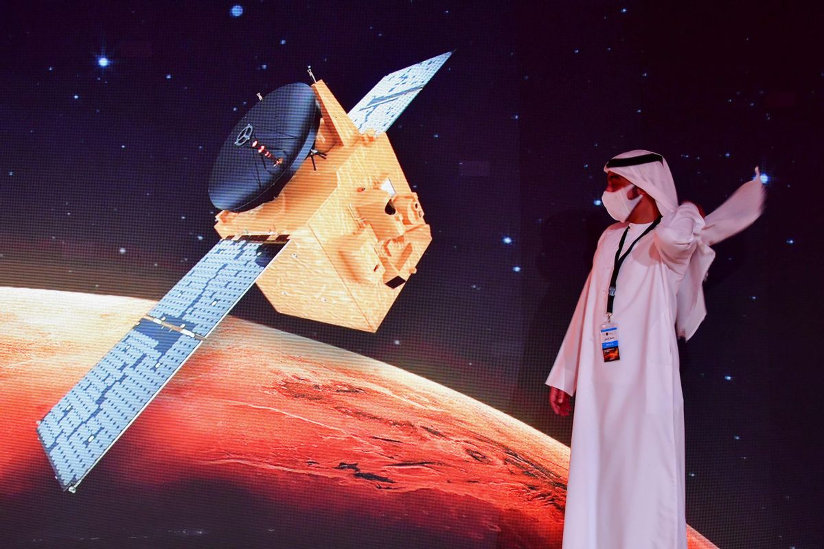 An Emirati walks past a screen displaying the "Hope" Mars probe at the Mohammed Bin Rashid Space Centre in Dubai on July 19, 2020, ahead of it's expected launch from Japan. - The probe is one of three racing to the Red Planet, with Chinese and US rockets also taking advantage of the Earth and Mars being unusually close: a mere hop of 55 million kilometres (34 million miles). "Hope" -- Al-Amal in Arabic -- is expected to start orbiting Mars by February 2021, marking the 50th anniversary of the unification of the UAE. (Photo by Giuseppe CACACE / AFP) (Photo by GIUSEPPE CACACE/AFP via Getty Images) (GIUSEPPE CACACE/AFP via Getty Images)