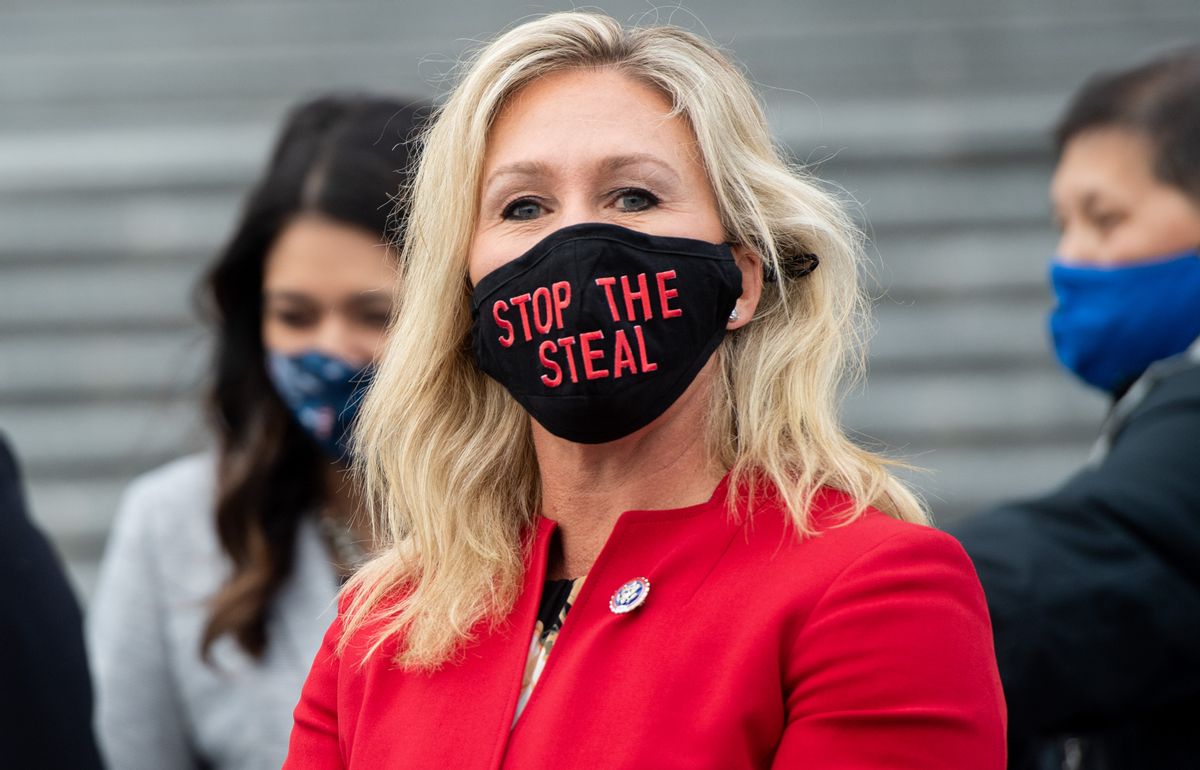 US Representative Marjorie Taylor Greene, Republican of Georgia, holds up a "Stop the Steal" mask while speaking with fellow first-term Republican members of Congress on the steps of the US Capitol in Washington, DC, January 4, 2021. - Donald Trump and Joe Biden head to Georgia on Monday to rally their party faithful ahead of twin runoffs that will decide who controls the US Senate, one day after the release of a bombshell recording of the outgoing president that rocked Washington.If Democratic challengers defeat the Republican incumbents in both races Tuesday, the split in the upper chamber of Congress will be 50-50, meaning incoming Vice President Kamala Harris will have the deciding vote. (Photo by SAUL LOEB / AFP) (Photo by SAUL LOEB/AFP via Getty Images) (SAUL LOEB/AFP via Getty Images (Jan. 4, 2021))