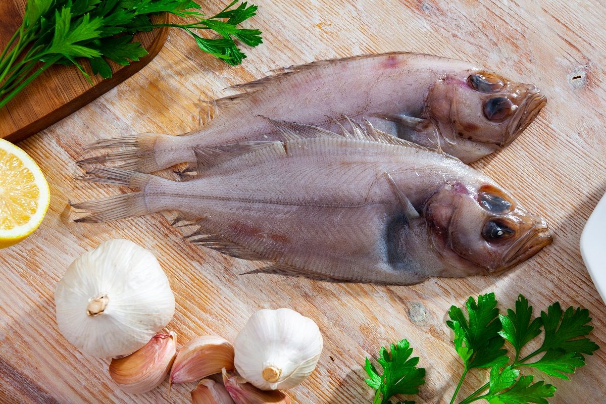 Raw seafood, fresh megrim sole flatfish on wooden board (Iakov Filimonov / Shutterstock)