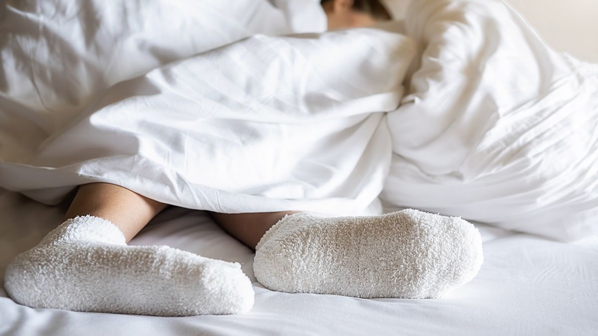 Woman feet in warm woolen socks on white bedclothes. Close up of young woman lying in bed at home. Relaxing concept. (Woman feet in warm woolen socks on white bedclothes. Close up of young woman lying in bed at home. Relaxing concept., ASCII, 117 comp (Sawek Kawila / EyeEm)